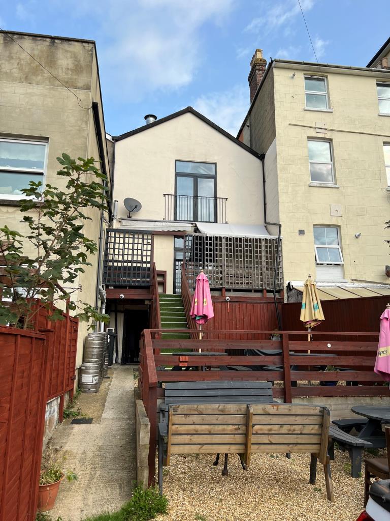Lot: 173 - TOWN CENTRE FREEHOLD THREE STOREY BAR WITH GARDEN AND PARKING - Rear view of the building